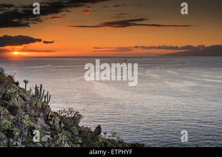 Coucher du soleil depuis les falaises près de Los Cristianos, à Tenerife, avec l'île de La Gomera et car-ferry de retour à Tenerife Banque D'Images