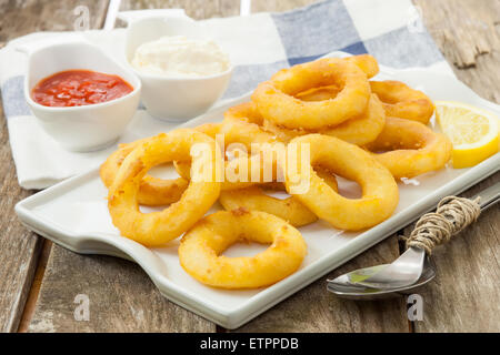 Calmars frits avec du citron et de la salade sur le bac blanc Banque D'Images