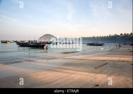 Les pêcheurs birmans désactiver chargement leurs bateaux tôt le matin sur la plage de Ngapali Myanmar Banque D'Images