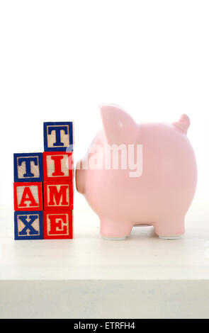 Fin de l'année financière Concept épargne tirelire avec blocs de construction, avec le temps de l'impôt sur table en bois blanc. Banque D'Images