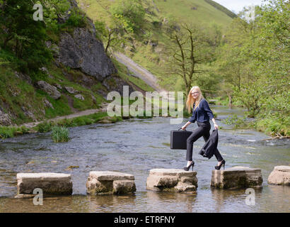 Jeune femme d'affaires à succès métaphore stepping stones Banque D'Images