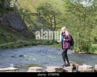 Jeune femme walkin gin dovedale crossing stepping stones Banque D'Images