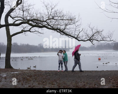 Les filles faisant un au lac selfies à Prospect Park, Brooklyn, New York. sur un jour de la fin de l'hiver. Banque D'Images