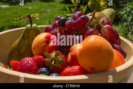 Un bol de fruits d'été,sur une table dans le jardin. Banque D'Images