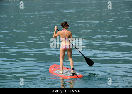 Woman in bikini Stand Up Paddle Surf paddle ou debout sur le lac d'Annecy en France Banque D'Images