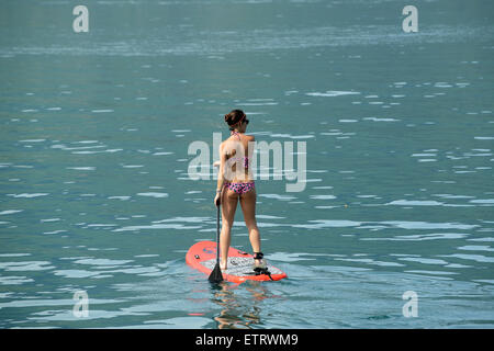 Woman in bikini Stand Up Paddle Surf paddle ou debout sur le lac d'Annecy en France Banque D'Images