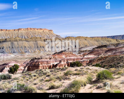 Près de hanksville, Utah - bentonite hills (premier plan), Factory Butte (arrière-plan) et l'arrière-plan lointain de montagnes (Henry). Banque D'Images