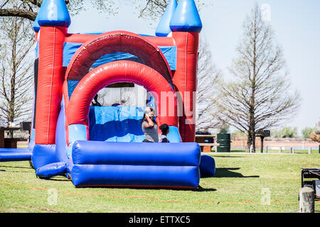 Deux jeunes filles afro-américains jouent dans un château gonflable bounce. New York, USA. Banque D'Images