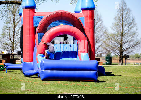 A young African American girl et un garçon jouer dans un château gonflable bounce. Oklahoma City, Oklahoma, USA. Banque D'Images