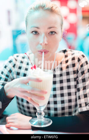 Woman drinking milk shake au diner. Banque D'Images