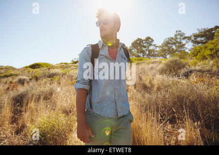 Image de jeune homme marche sur sentier de montagne à la route. Caucasian man en randonnée dans la nature sur une journée ensoleillée. Banque D'Images
