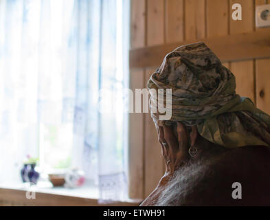 Seule vieille femme assis tenant sa tête avec une main de la vie solitaire contemplant Banque D'Images