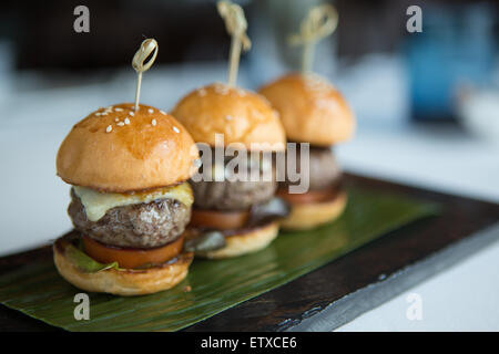 Trio de mini-hamburgers servis sur une banane partir. Banque D'Images