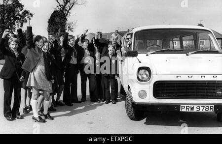 Le directeur de l'Blue Coat School, Coventry, M. W.J Grimes, essaie l'nouveau bus 12 places sous les applaudissements de certains des élèves qui ont aidé à recueillir l'argent pour elle. Ils ont soulevé la £1 400 en une journée par diverses activités parrainées pendant le congé de Pâques Banque D'Images