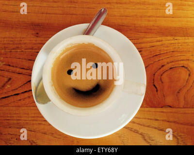 Tasse de café avec plus de smiley surface en bois Banque D'Images