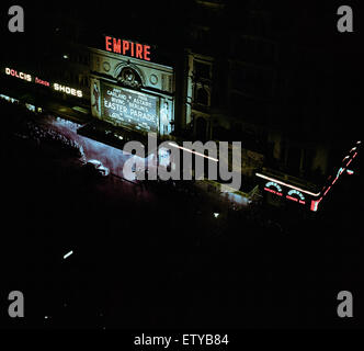Lumières de Londres. Cinéma Empire illuminée alors que des foules d'attente à regarder le film parade de Pâques avec Judy Garland et Fred Astaire . Circa 1948. Banque D'Images