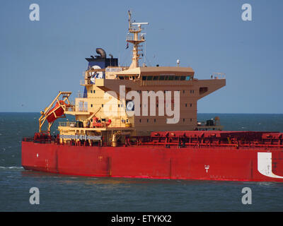 L'UBC Oristano, IMO 9463657, est un vraquier photographié dans le port de Rotterdam. L'image capture le navire le long d'un remorqueur et d'une barge, se préparant aux opérations de chargement ou de déchargement de la cargaison dans le port. Ce navire fait partie des opérations de transport maritime mondiales, naviguant à la fois sur les routes océaniques et fluviales pour transporter des marchandises à travers les eaux internationales. Banque D'Images