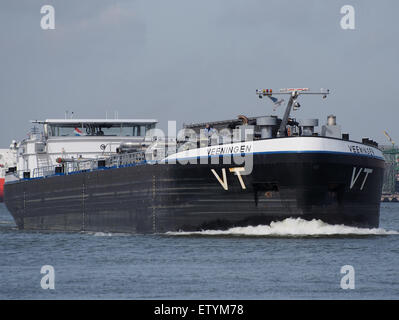 Le 'Veeningen' (ENI 02332021) est capturé dans le port de Rotterdam. L'image montre le navire, qui fait partie d'une plaque tournante maritime très fréquentée, soulignant son rôle dans le transport de marchandises et le transport pétrolier. La scène comprend divers navires, y compris des pétroliers et des barges, amarrés au port. Banque D'Images