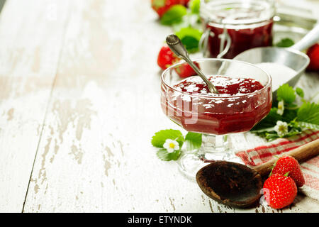 Dans un pot de confiture de fraises sur fond de bois Banque D'Images