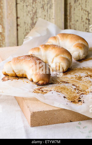 Des rouleaux au four sur papier cuisson du four et pierre sur nappe gris clair Banque D'Images