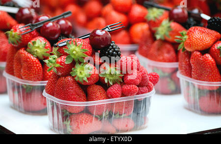 Mélange de fruits frais mûrs framboise, fraise, mûre et myrtille dans les boîtes en plastique jetable avec fourche de market Banque D'Images