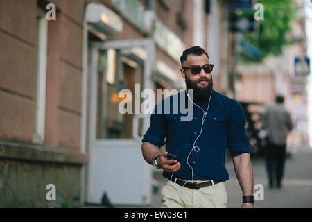 Homme barbu va et écoute de la musique Banque D'Images