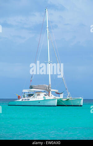 Belle vue sur un yacht catamaran ancré dans une baie des Caraïbes, personne à bord, avec drapeau français Banque D'Images