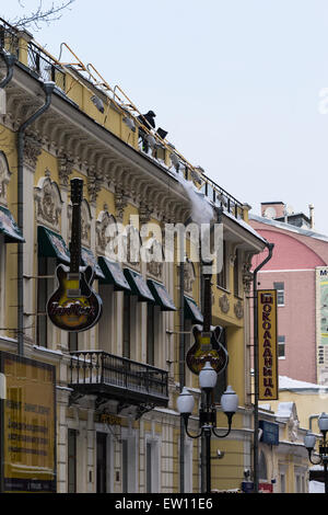 Un travailleur non identifiés, méconnaissable supprime la neige de la toiture de l'ancien bâtiment dans la rue Arbat de Moscou Banque D'Images