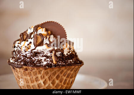La crème glacée tourbillonné dans Waffle Bowl garnie de bonbons au beurre d'arachide au chocolat Banque D'Images