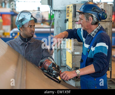 Fuerstenwalde, Allemagne. 09Th Juin, 2015. 26 ans d'asile Hamza Ahmed (L) à partir de la Somalie fonctionne avec le contremaître pour la coupe, Thorsten Muschack, sur un segment de l'acier d'un mât de l'éolienne à l'entreprise STC Reuther GmbH à Fuerstenwalde, Allemagne, 02 juin 2015. Photo : Patrick Pleul/dpa/Alamy Live News Banque D'Images