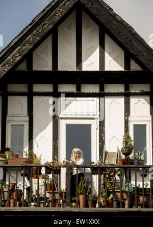 Une femme à Willesden Green tend à son jardin sur son balcon comme tempertures frappé 17 degrés le lundi de Pâques avec jardin : adjudication où : London, Royaume-Uni Quand : 06 Jan 2015 C Banque D'Images