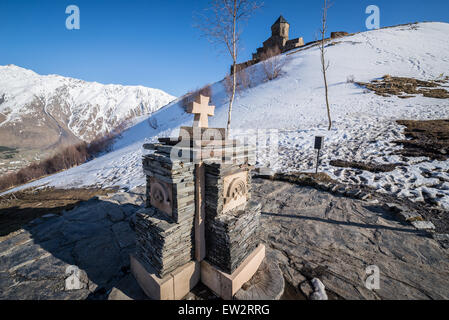 Petite croix en pierre à côté de l'église Holy Trinity (Tsminda Sameba) à partir de 14e siècle à proximité du village, ville Stepantsminda Gergeti et Mo Banque D'Images