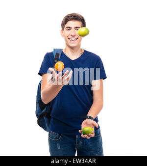 Casual young man jongle avec des fruits isolé sur fond blanc Banque D'Images