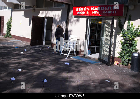 Cologne, Allemagne. 17 Juin, 2015. Un policier se tient devant un kiosque et fait un coup de téléphone à Cologne, Allemagne, 17 juin 2015. Une femme et deux hommes sont gravement blessés après une fusillade devant le kiosque d'hier soir. Photo : MARIUS BECKER/dpa/Ala Banque D'Images