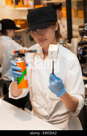 Un membre du personnel présente une S'more au cours de l'événement pré-ouverture de la nouvelle pâtisserie ''Dominique Ansel Bakery'' dans Omotesando Hills le 17 juin 2015, Tokyo, Japon. La nouvelle marque est connue pour ses pâtisseries Cronuts ; un croissant doughnut création fusion par le Chef Dominique Ansel et est déjà très populaire à New York. C'est la première fois qu'il ouvrira une succursale internationale. Le Japon a connu un boom récent dans les détaillants alimentaires surtout d'essayer d'être la dernière nouvelle tendance à Tokyo. Le magasin ouvre ses portes au public le 20 juin et les lignes longues sont attendus. (Photo de Banque D'Images