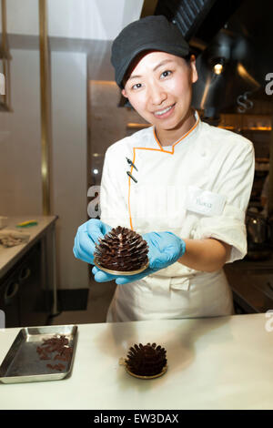 Un membre du personnel montre une pomme de pin d'épice durant la phase pré-événement d'ouverture de la nouvelle pâtisserie ''Dominique Ansel Bakery'' dans Omotesando Hills le 17 juin 2015, Tokyo, Japon. La nouvelle marque est connue pour ses pâtisseries Cronuts ; un croissant doughnut création fusion par le Chef Dominique Ansel et est déjà très populaire à New York. C'est la première fois qu'il ouvrira une succursale internationale. Le Japon a connu un boom récent dans les détaillants alimentaires surtout d'essayer d'être la dernière nouvelle tendance à Tokyo. Le magasin ouvre ses portes au public le 20 juin et les lignes longues sont attendus. (P Banque D'Images