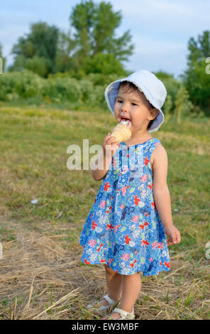 Belle petite fille mange de la glace en été Banque D'Images