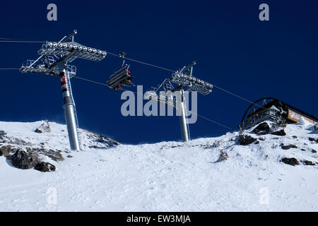 Vue sur le télésiège de ski skieurs transport vue d'en bas contre un ciel bleu foncé Banque D'Images