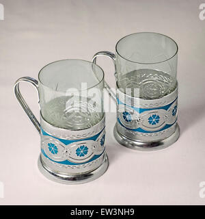 Deux gobelets en verre transparent dans des porte-gobelets en métal Banque D'Images