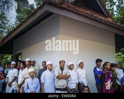 Yaha, Yala, la Thaïlande. 17 Juin, 2015. Les musulmans thaïlandais s'abriter de la pluie au cours de l'Hilal dans Yaha. Au cours d'une pause dans la pluie et les nuages, les gens ont vu le croissant de lune et le début du Ramadan a été déclarée. Des milliers de gens sont venus dans la province de Yala District Yaha de la Thaïlande de l'Hilal - la première observation du croissant de lune qui marque le début officiel du mois du Ramadan. Malgré le temps nuageux et des averses de pluie intermittente, la lune a été aperçu et chefs religieux déclarés début du Ramadan. © Jack Kurtz/ZUMA/Alamy Fil Live News Banque D'Images