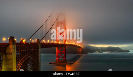 Le Golden Gate Bridge foggy éclairement sur le coucher du soleil Banque D'Images
