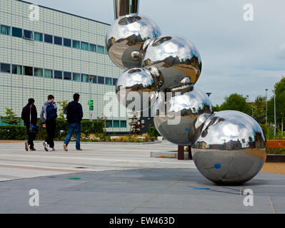 Les élèves en passant devant la sculpture et bâtiments du campus de l'Université Loughborough Leicestershire dans l'East Midlands England UK Banque D'Images