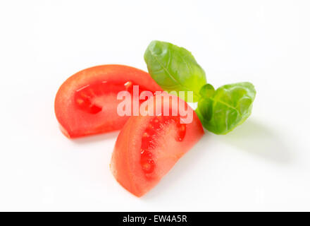 Quartiers de tomates fraîches sur fond blanc Banque D'Images