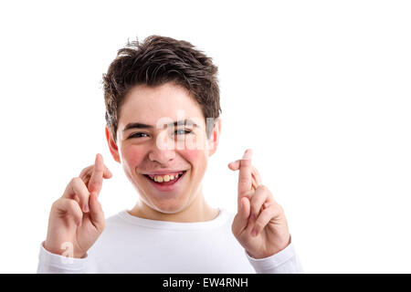 Amérique jeune garçon avec l'acné dans un livre blanc T-shirt smiles crossing doigts des deux mains comme geste superstitieux de chance Banque D'Images