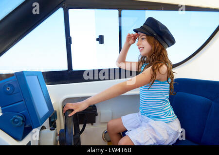 Kid girl prétendant être un capitaine marin bateau dans la roue intérieure holding Banque D'Images