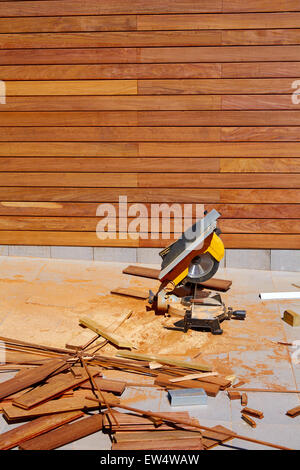 Installation d'une clôture en bois Ipe avec scie circulaire table Carpenter et de sciure Banque D'Images