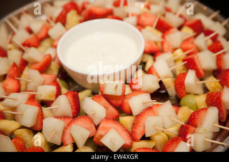 Cocktail de fruits sur des bâtons avec une trempette à la crème fraîche Banque D'Images