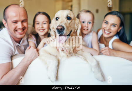Entouré d'animaux par famille de quatre sitting on sofa Banque D'Images