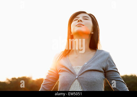 Jeune femme fermeture yeux with arms outstretched Banque D'Images