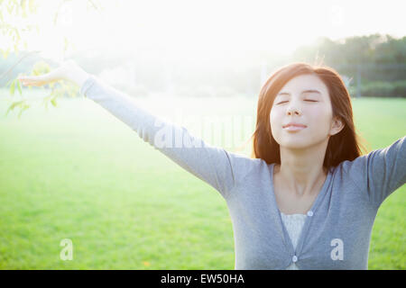 Jeune femme fermeture yeux with arms outstretched Banque D'Images